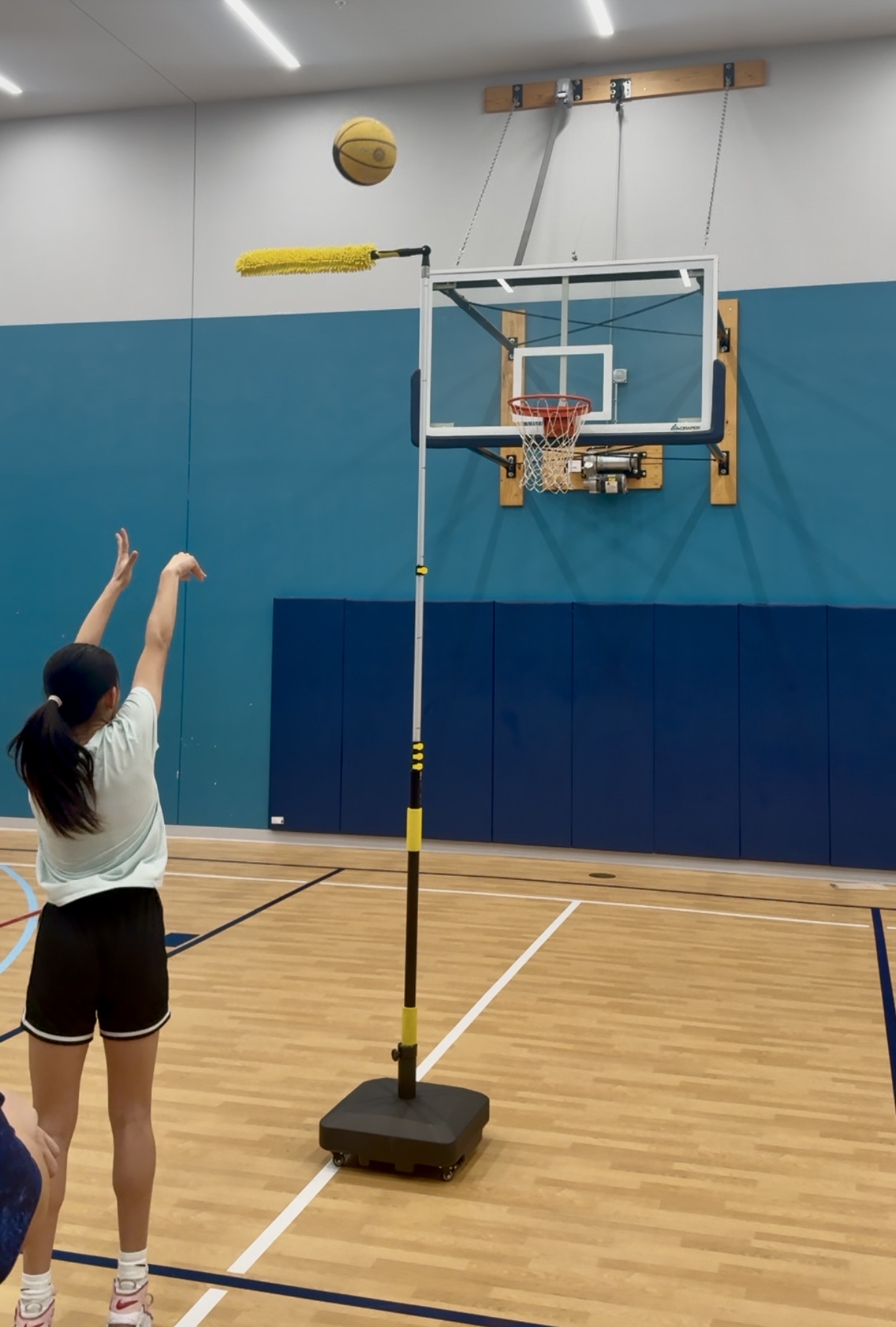 High-arc release over The Archer guide on a blue-wall gym court